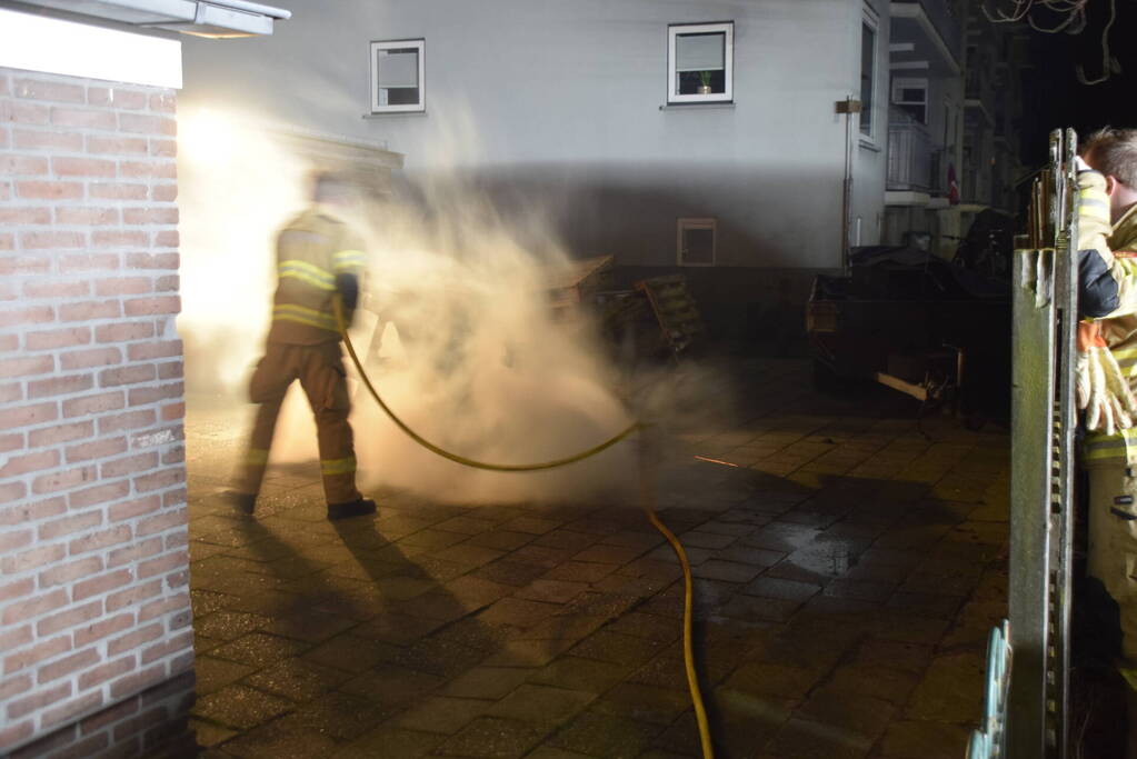 Brandweer blust brandende vuurton in achtertuin