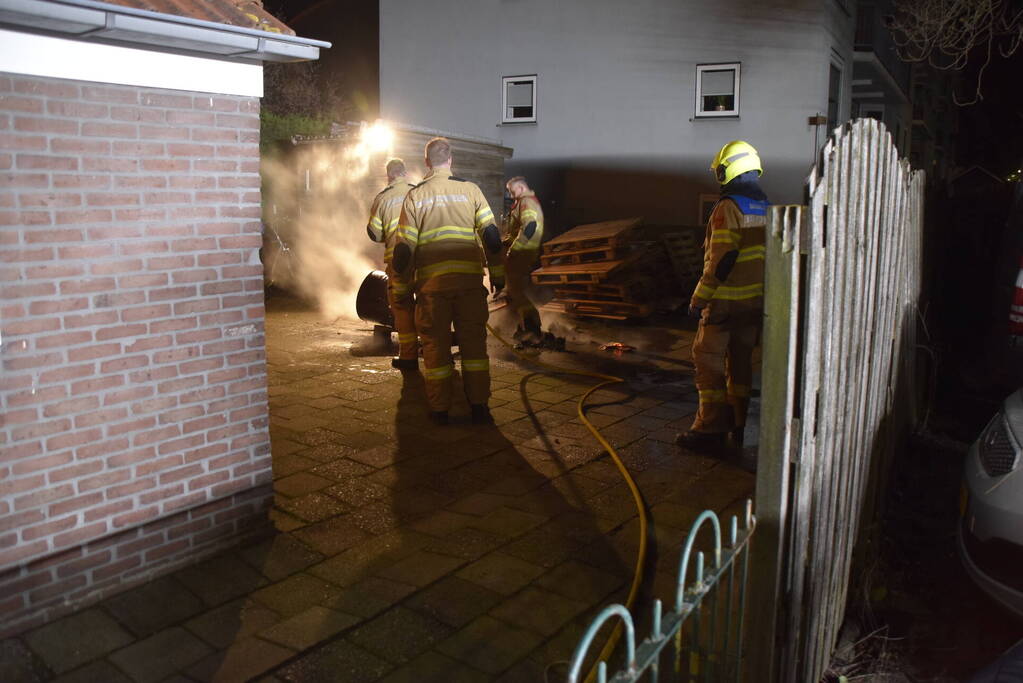 Brandweer blust brandende vuurton in achtertuin