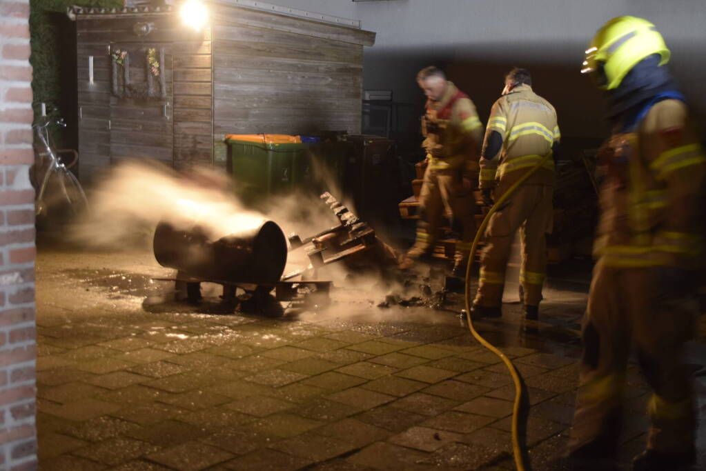 Brandweer blust brandende vuurton in achtertuin