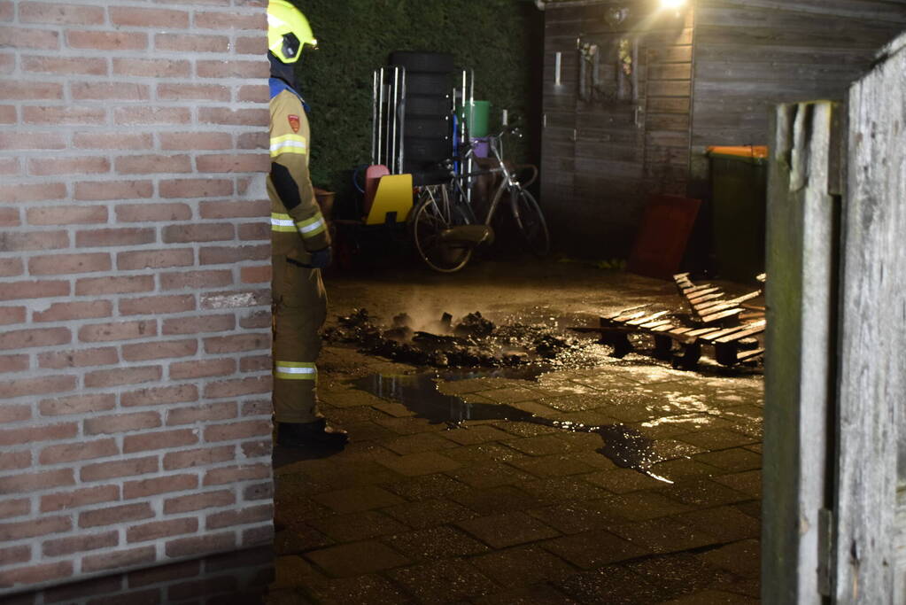 Brandweer blust brandende vuurton in achtertuin