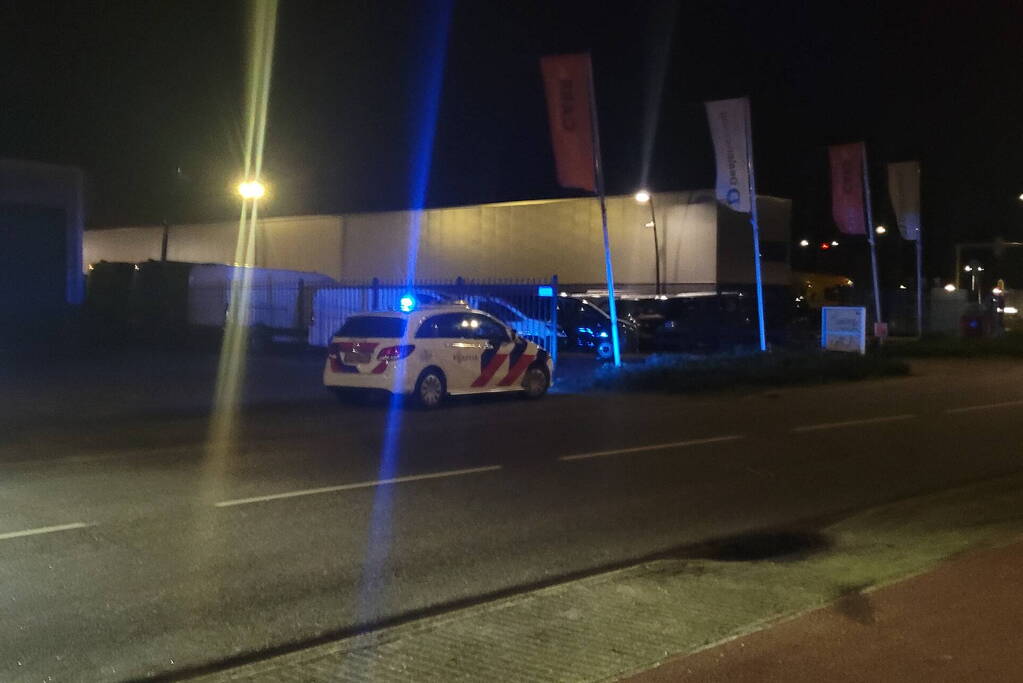 Brandweer blust brandend heg naast pand