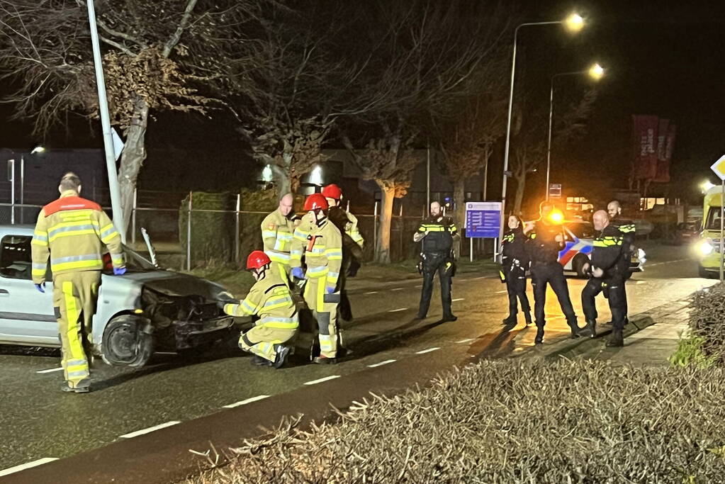Auto op zijn zijkant na botsing met lantaarnpaal