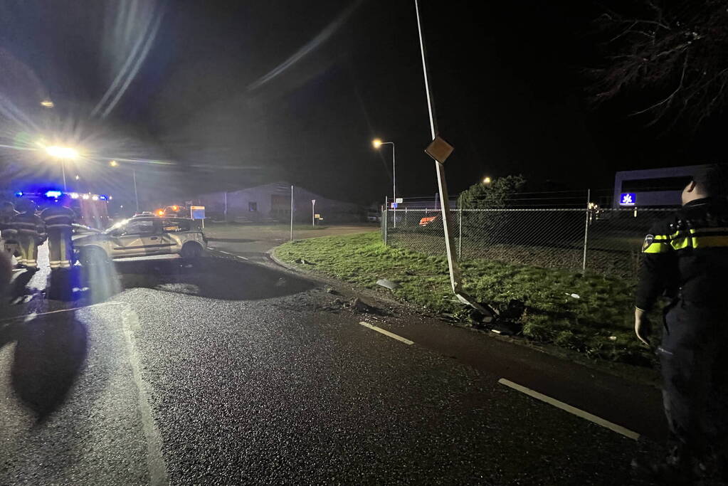 Auto op zijn zijkant na botsing met lantaarnpaal