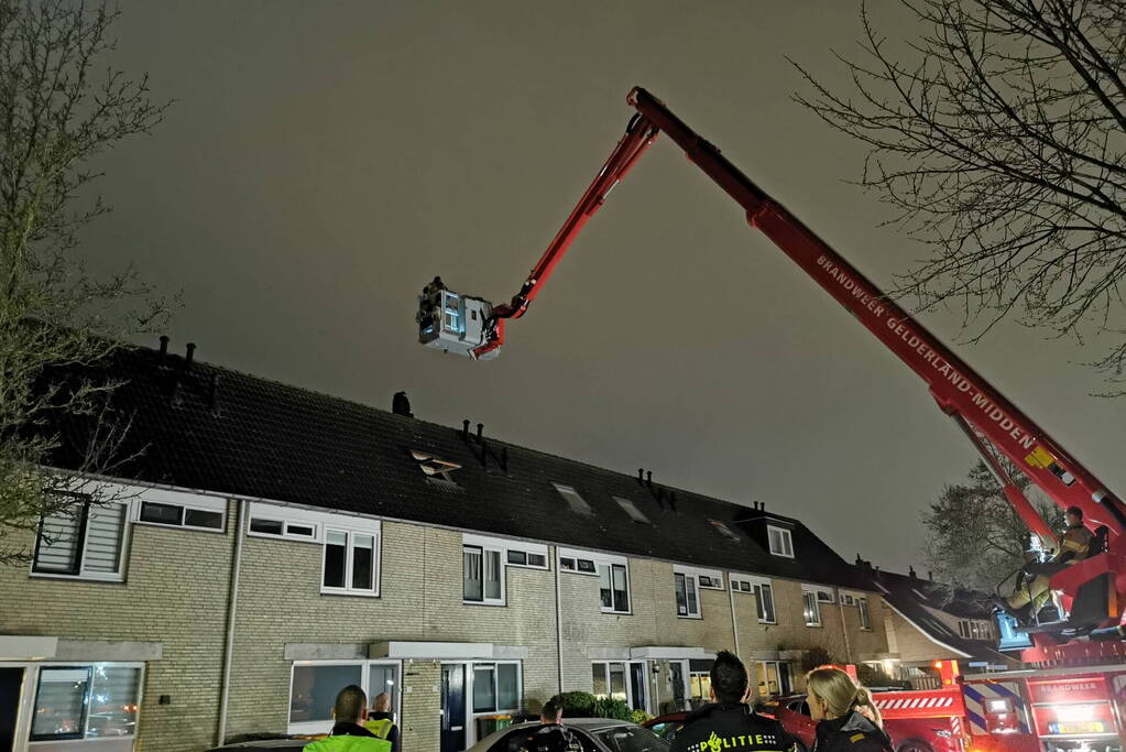 Persoon klimt op dak van woning