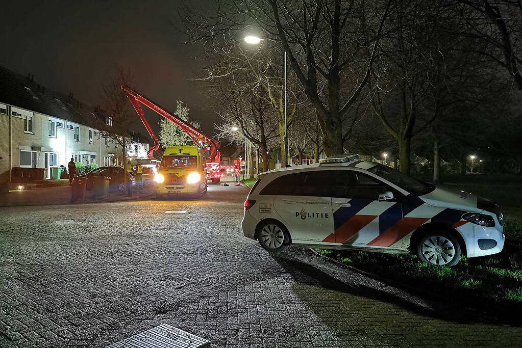 Persoon klimt op dak van woning