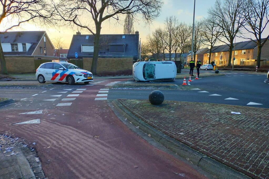 Auto belandt op zijn kant op rotonde