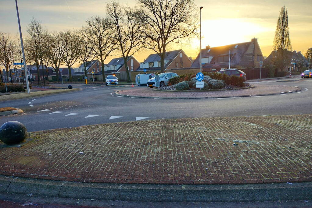 Auto belandt op zijn kant op rotonde
