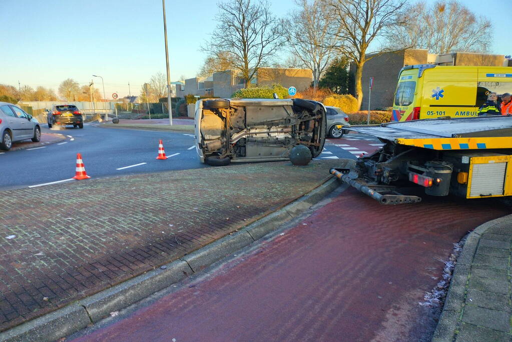 Auto belandt op zijn kant op rotonde