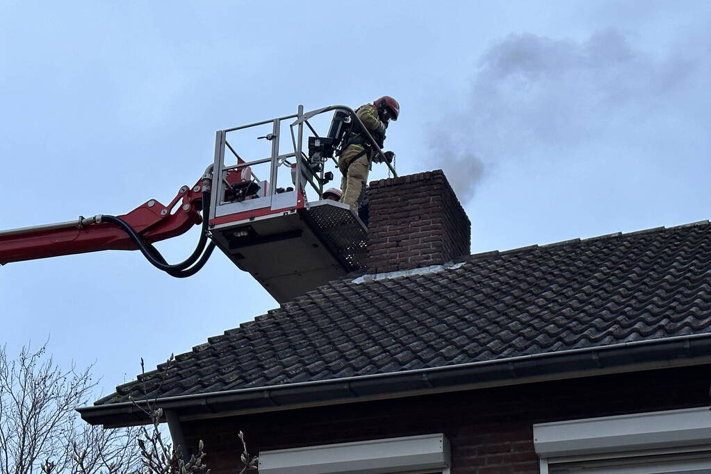 Brandweer veegt schoorsteen na brand
