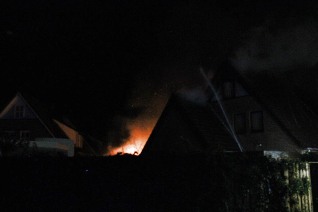 Uitslaande brand in tuinhuis slaat over naar woning
