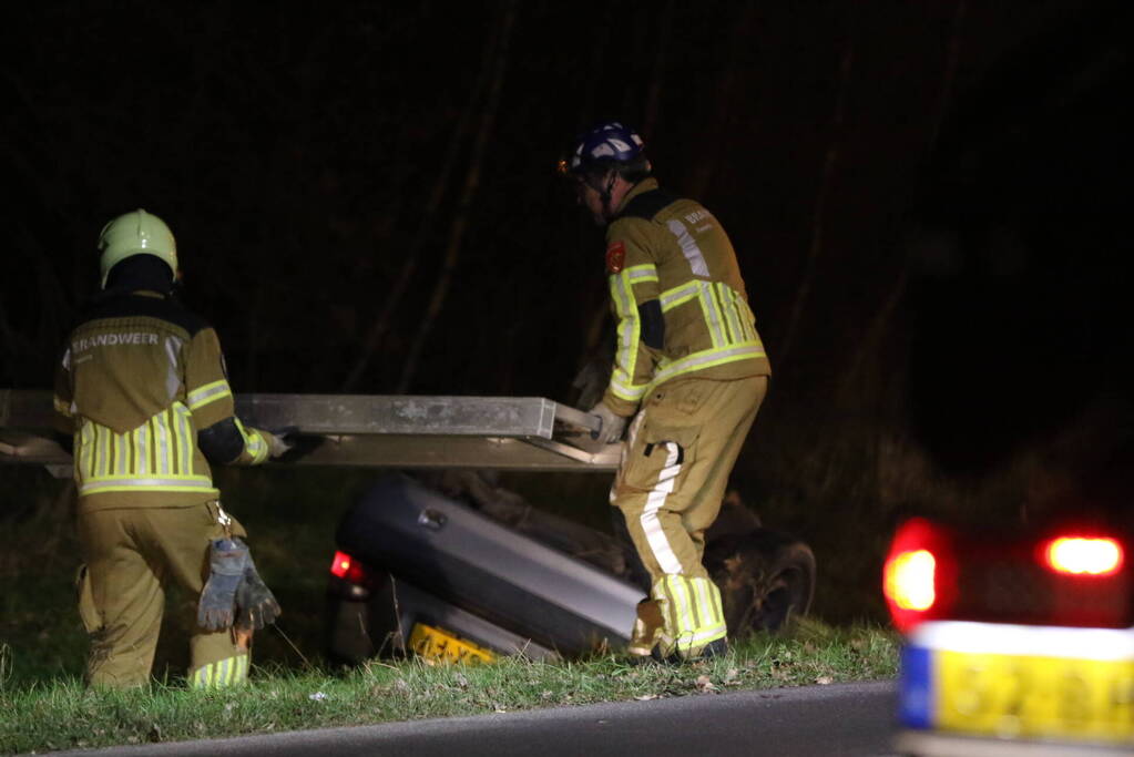 Auto op zijn kop in droge sloot