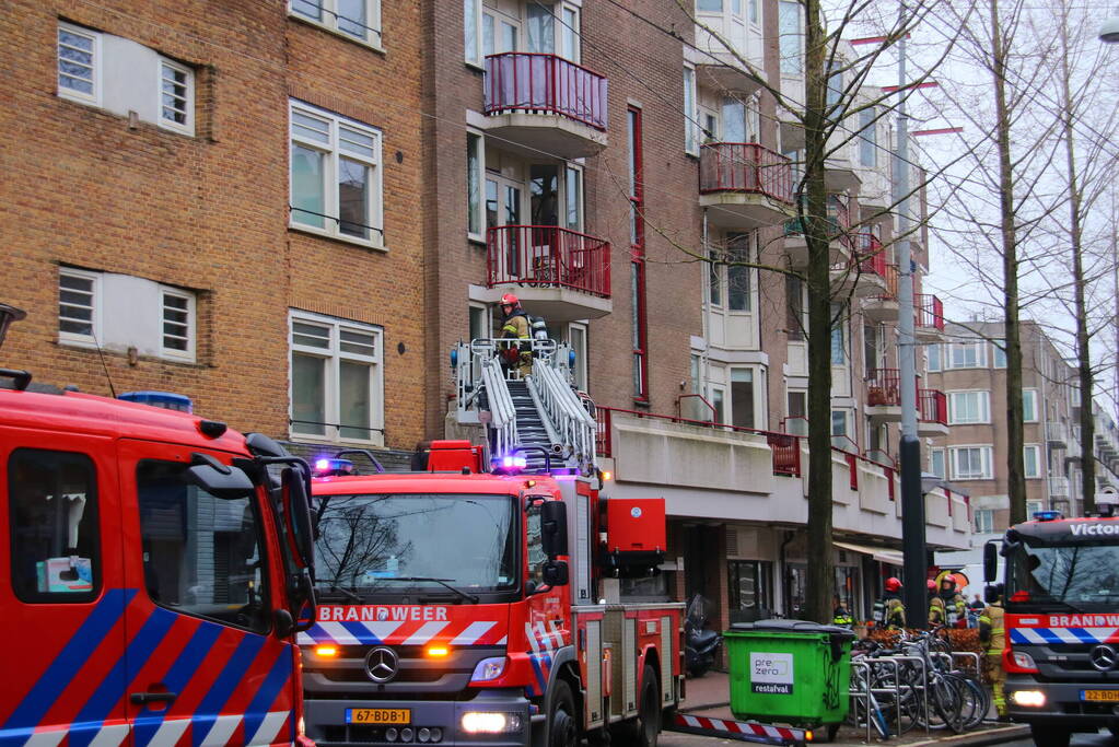 Brandweer met veel wagens naar woningbrand
