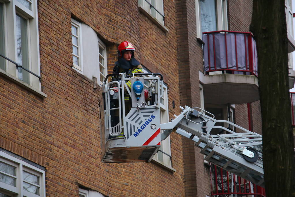 Brandweer met veel wagens naar woningbrand