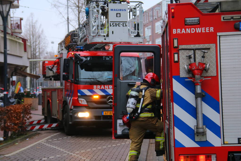 Brandweer met veel wagens naar woningbrand