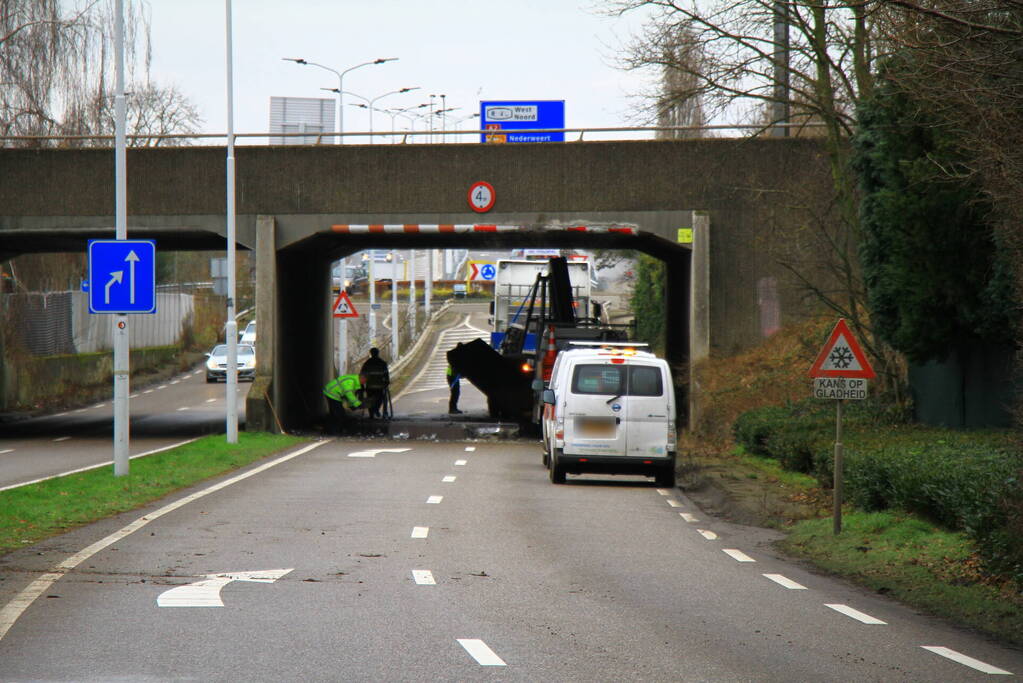 Vrachtwagenchauffeur rijdt met lading tegen spoorviaduct