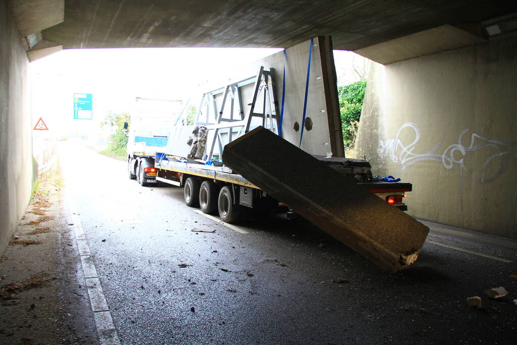 Vrachtwagenchauffeur rijdt met lading tegen spoorviaduct
