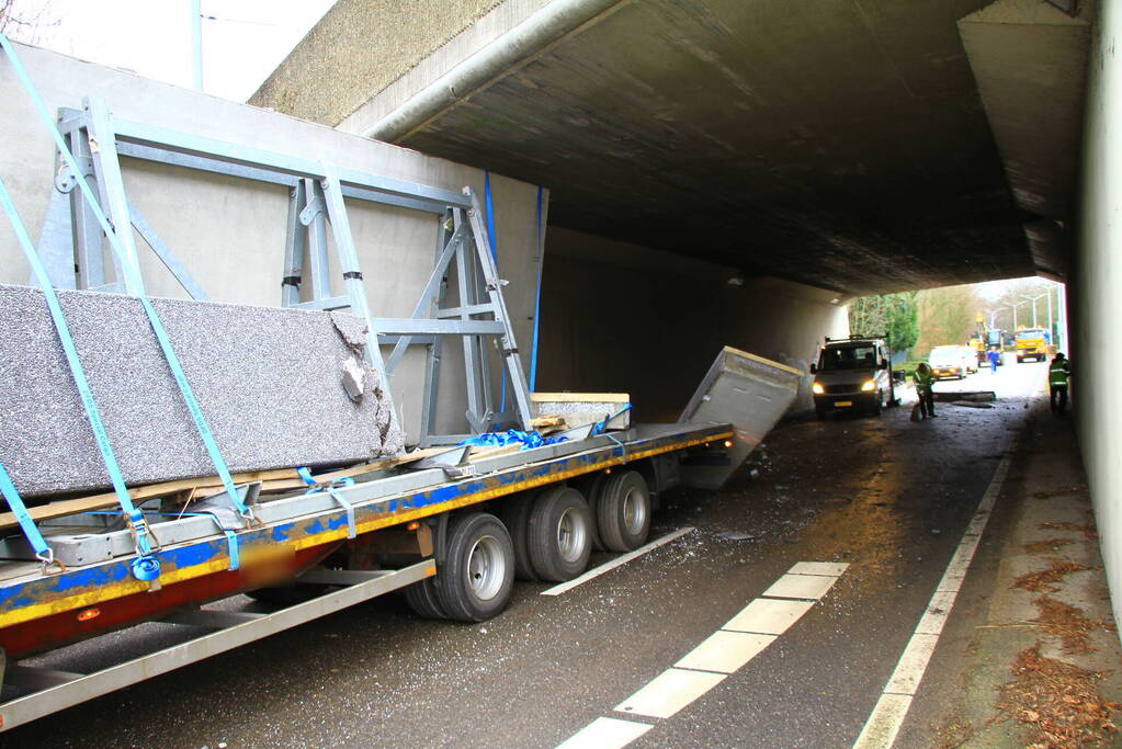 Vrachtwagenchauffeur rijdt met lading tegen spoorviaduct
