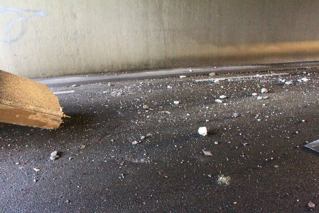 Vrachtwagenchauffeur rijdt met lading tegen spoorviaduct