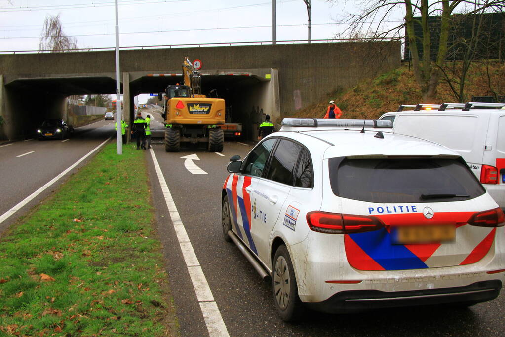 Vrachtwagenchauffeur rijdt met lading tegen spoorviaduct