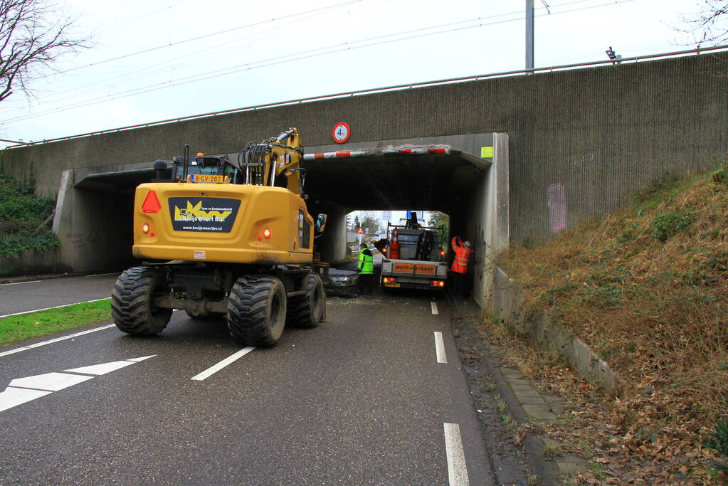 Vrachtwagenchauffeur rijdt met lading tegen spoorviaduct