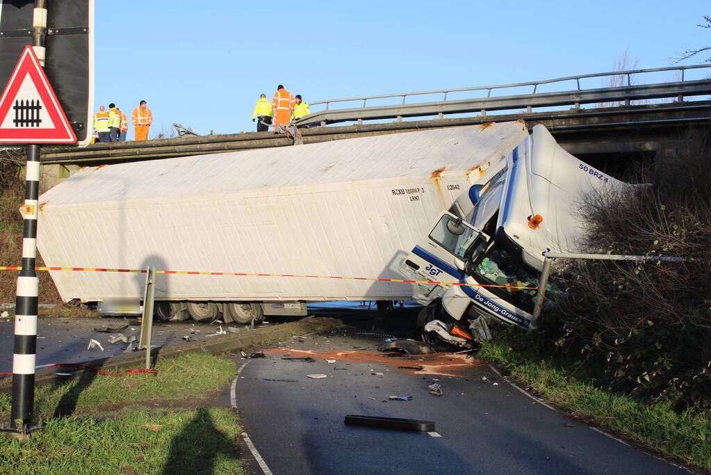 Vrachtwagen rijdt van snelweg af en plet bestelbus