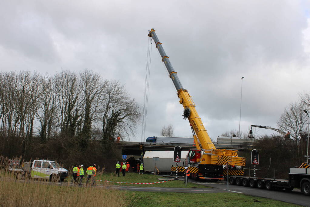 Vrachtwagen rijdt van snelweg af en plet bestelbus