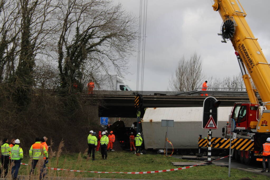 Vrachtwagen rijdt van snelweg af en plet bestelbus