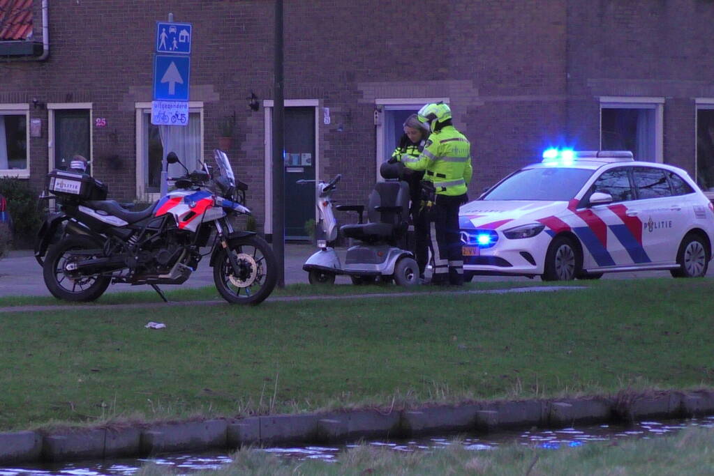 Persoon met scootmobiel te water