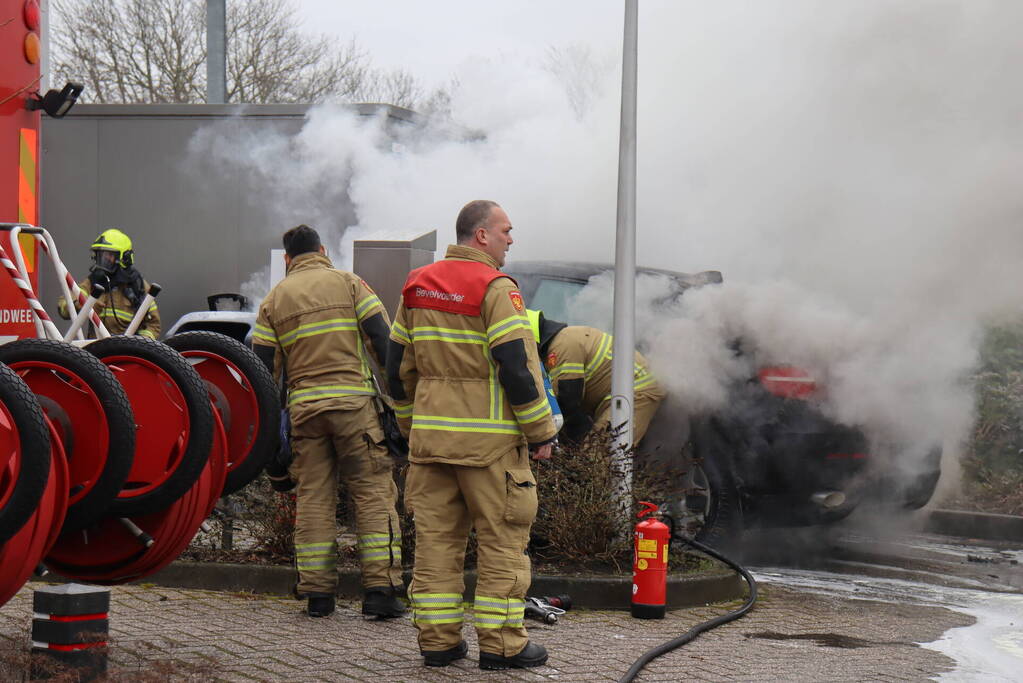 Auto vliegt in brand voor ingang carwash