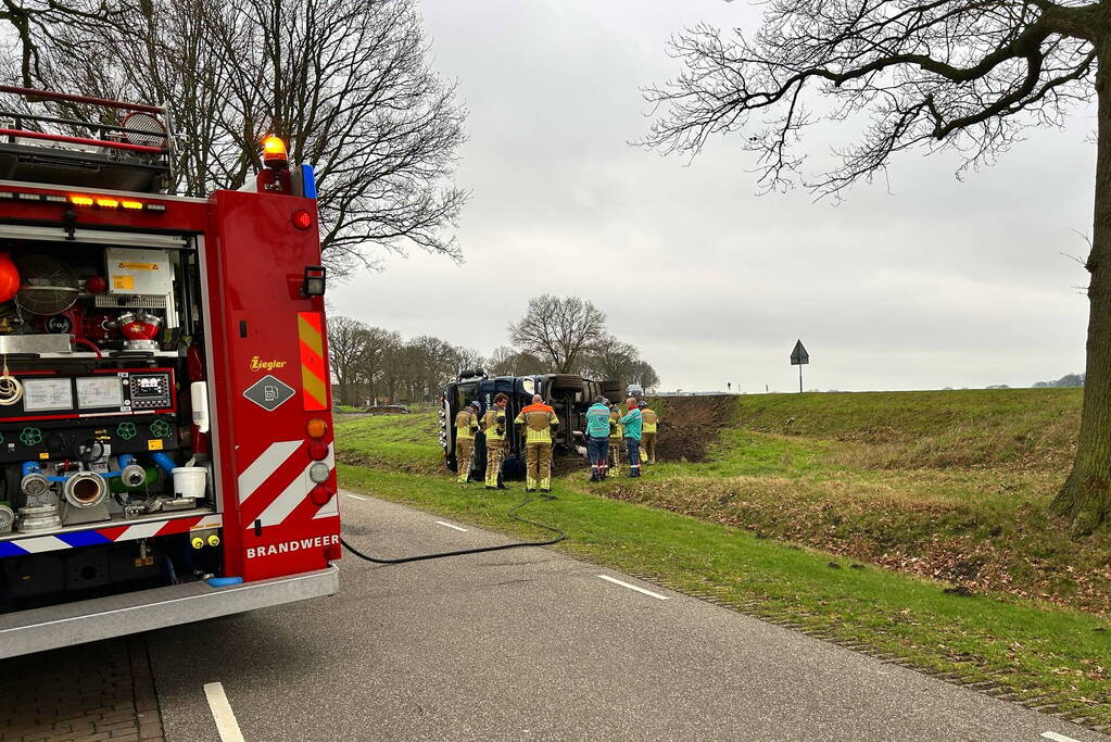 Vrachtwagen belandt op zijn kant naast de weg
