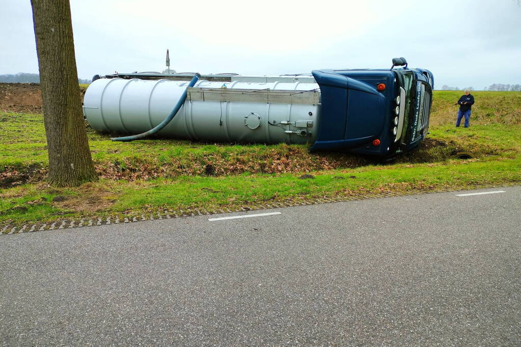 Vrachtwagen belandt op zijn kant naast de weg