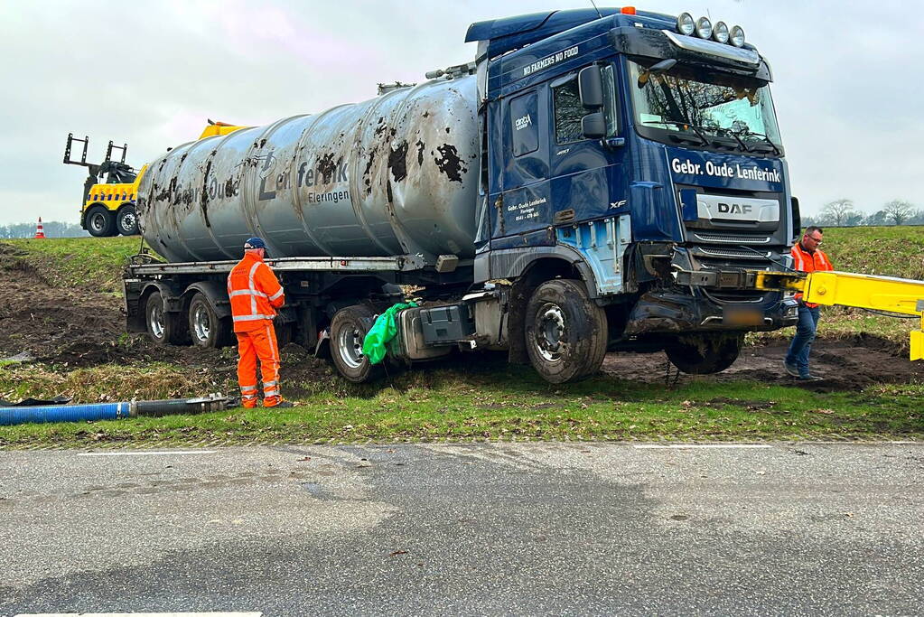 Vrachtwagen belandt op zijn kant naast de weg