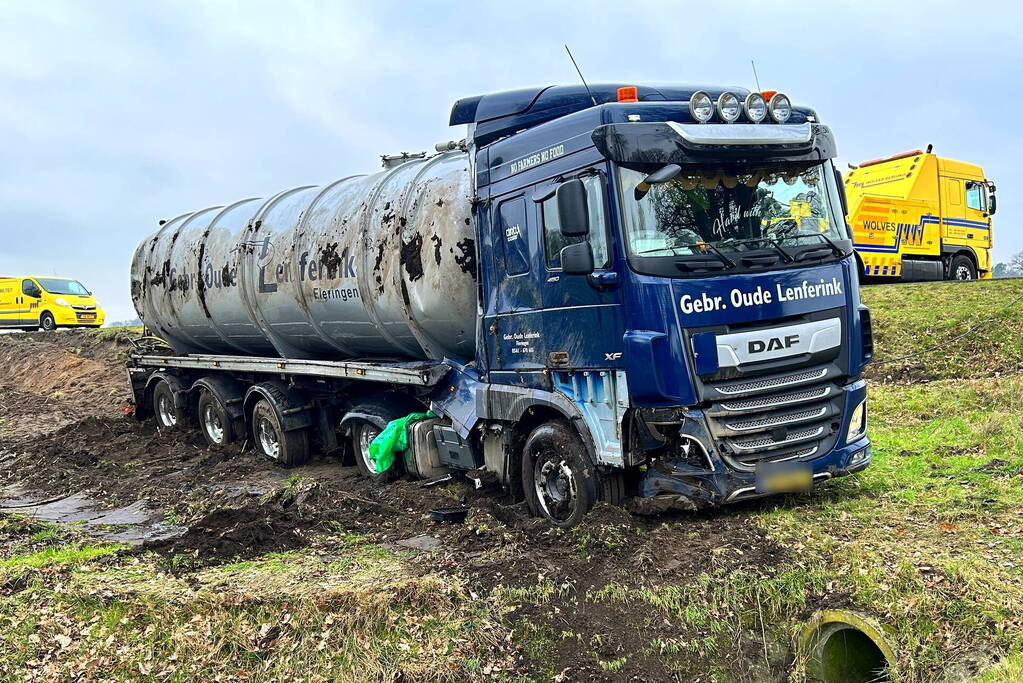 Vrachtwagen belandt op zijn kant naast de weg