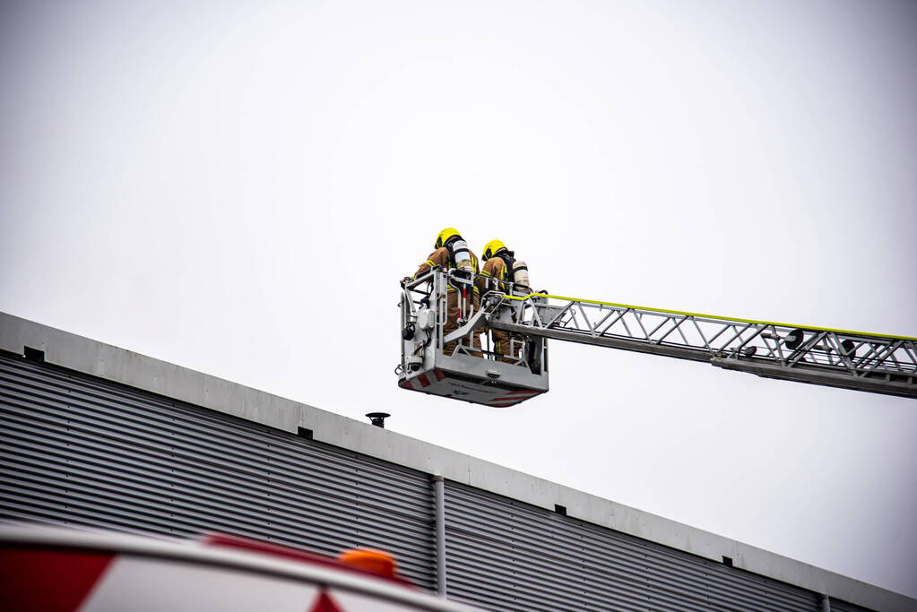 Zwarte rookwolken uit bedrijfsverzamelgebouw