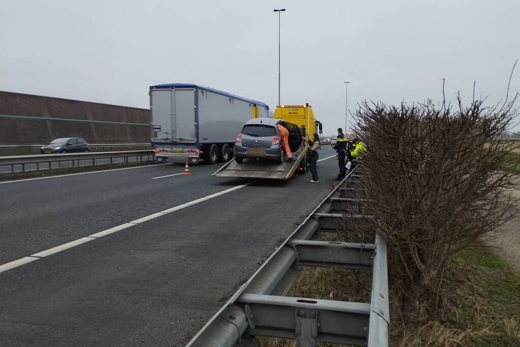 Personenauto klapt bovenop vrachtwagen
