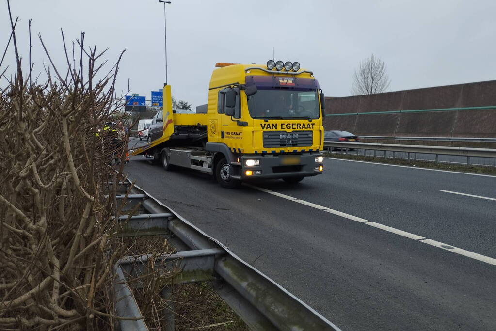 Personenauto klapt bovenop vrachtwagen