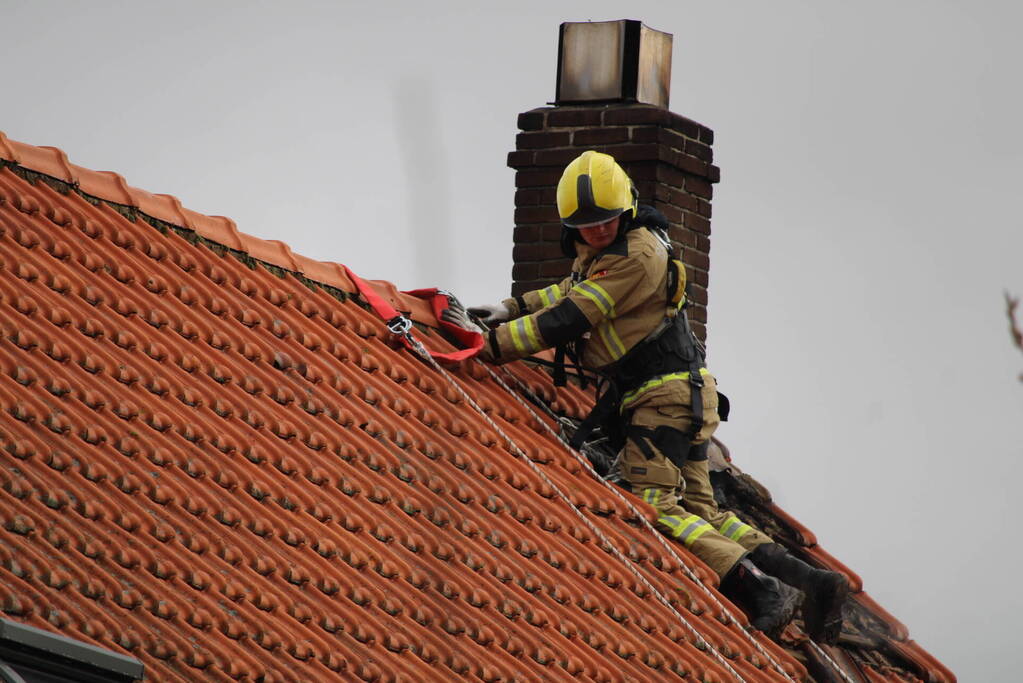 Dak beschadigd door brand, brandweerman onwel tijdens inzet