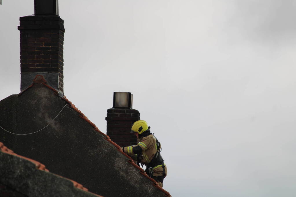 Dak beschadigd door brand, brandweerman onwel tijdens inzet