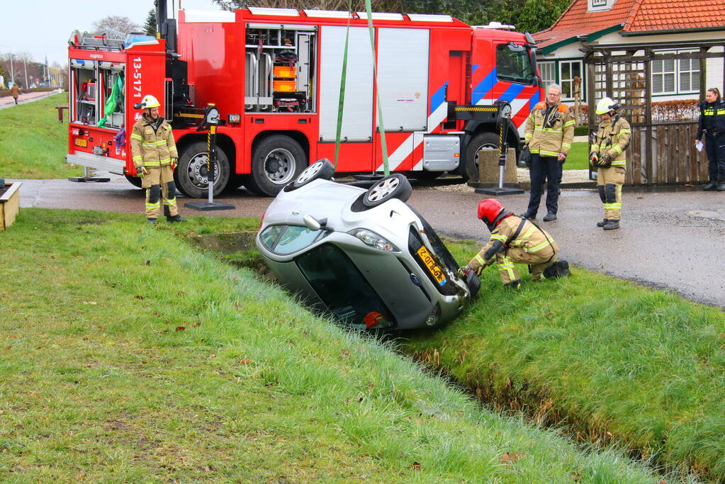 Brandweer takelt auto uit greppel