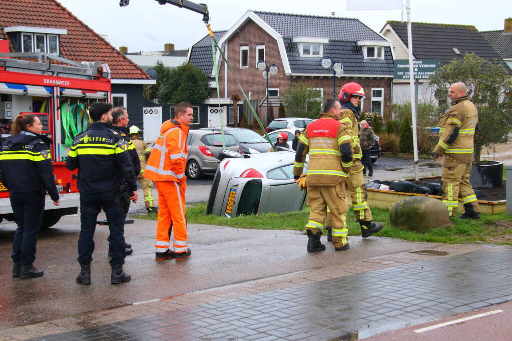 Brandweer takelt auto uit greppel