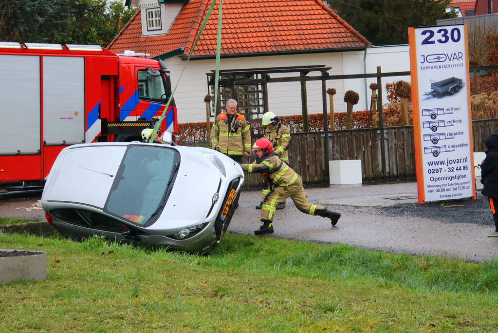 Brandweer takelt auto uit greppel