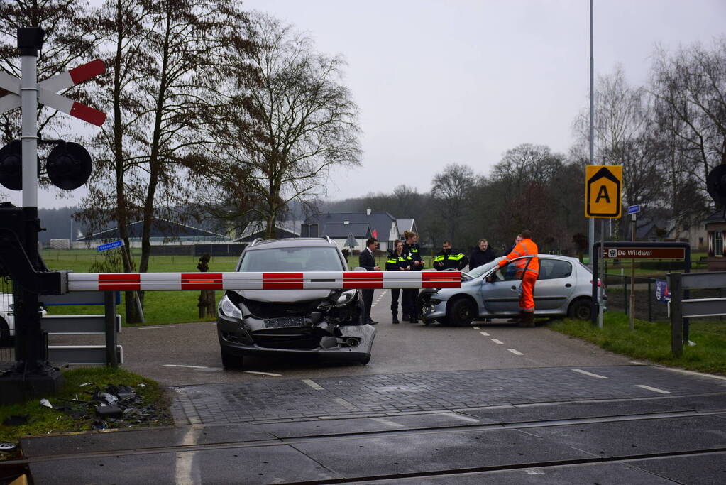 Twee auto's botsen tegen elkaar bij spoorwegovergang