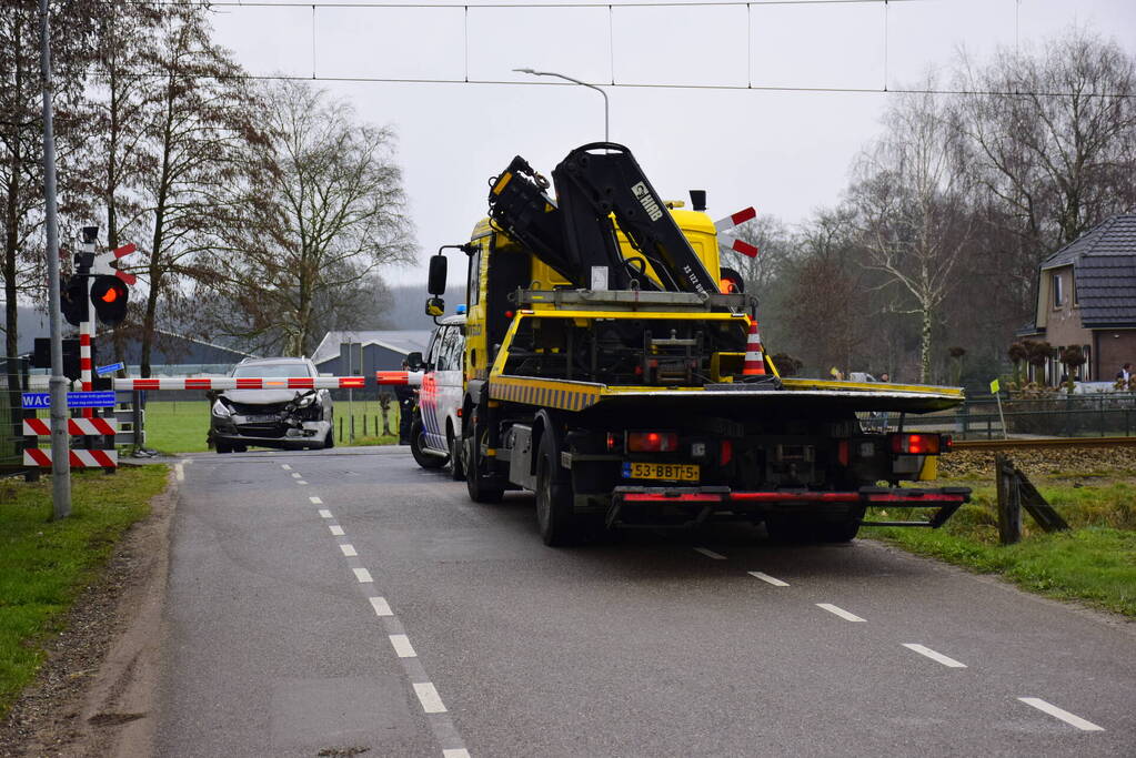 Twee auto's botsen tegen elkaar bij spoorwegovergang