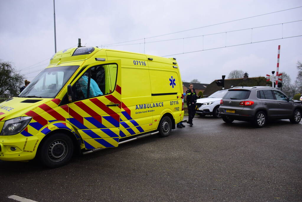 Twee auto's botsen tegen elkaar bij spoorwegovergang