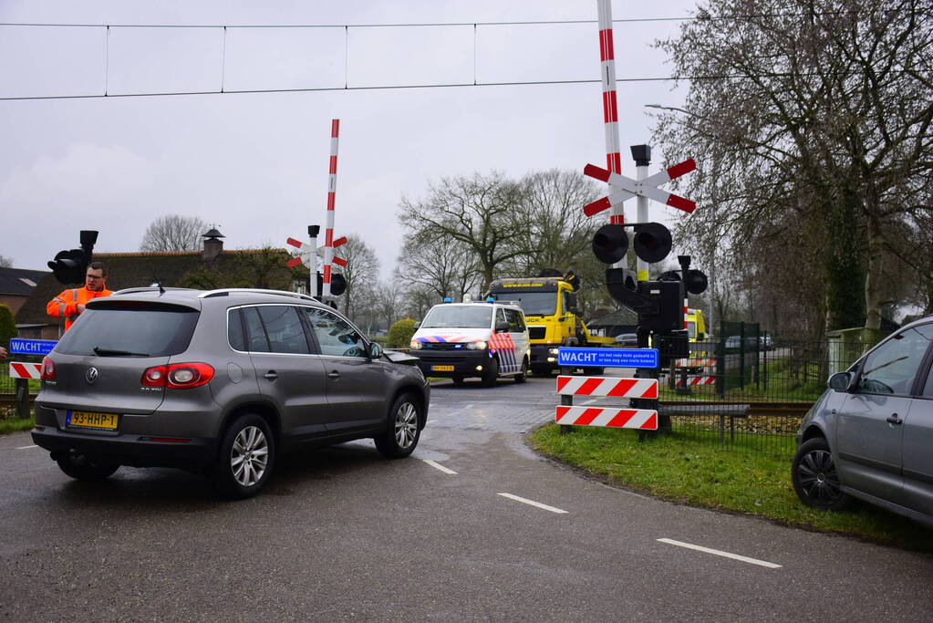 Twee auto's botsen tegen elkaar bij spoorwegovergang