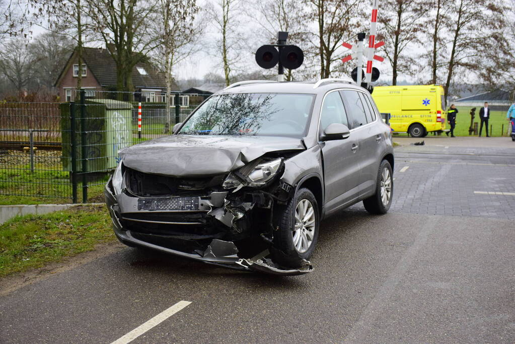 Twee auto's botsen tegen elkaar bij spoorwegovergang