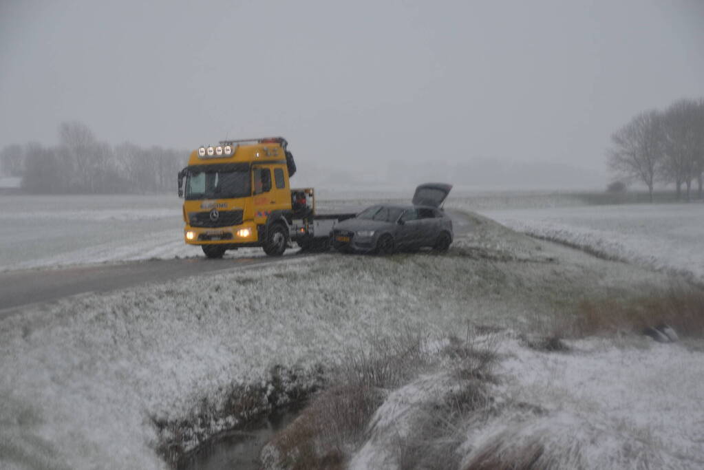 Twee personenauto's in berm van dijk belandt