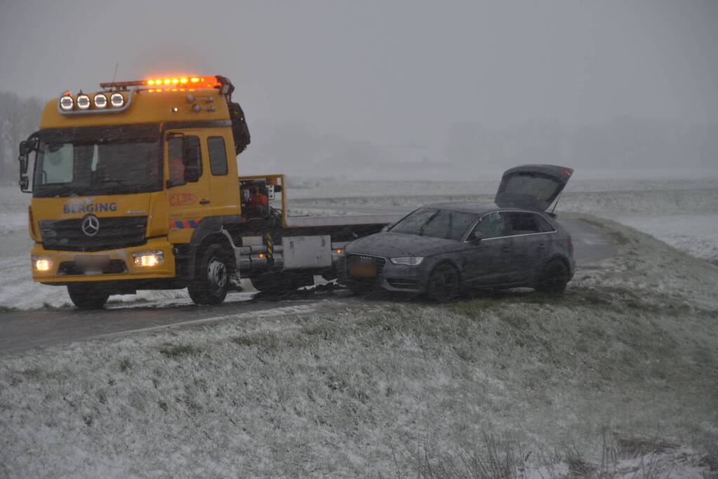 Twee personenauto's in berm van dijk belandt