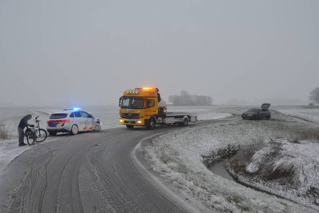 Twee personenauto's in berm van dijk belandt