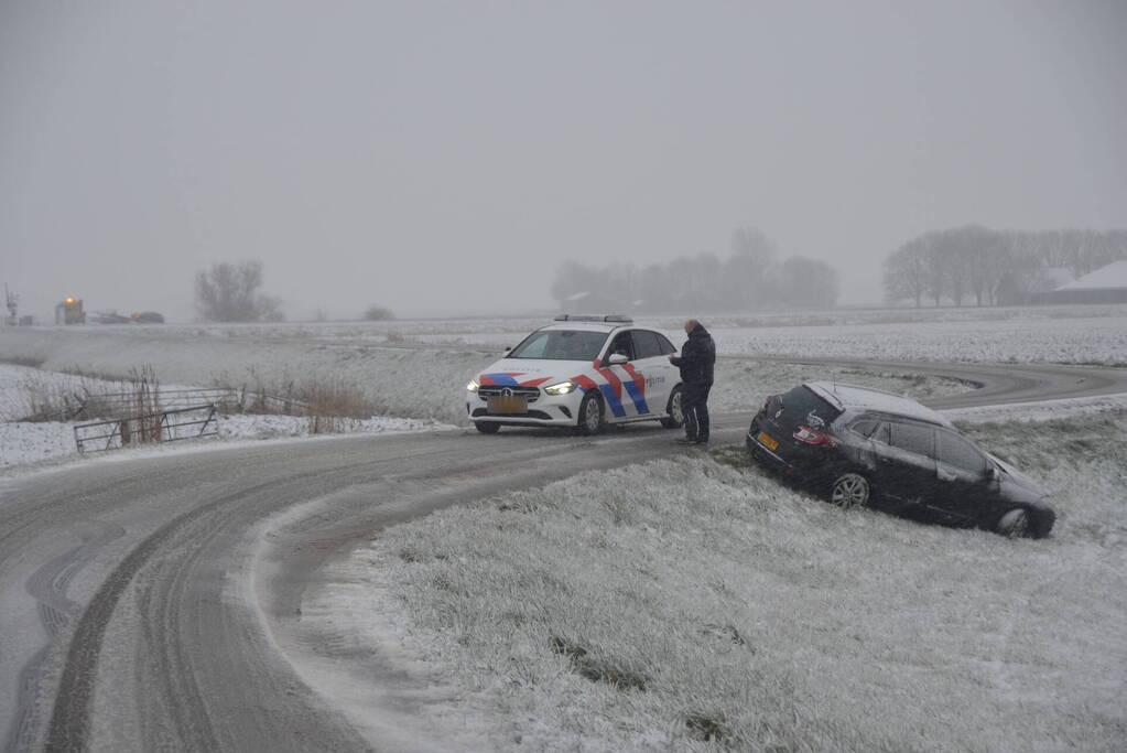Twee personenauto's in berm van dijk belandt